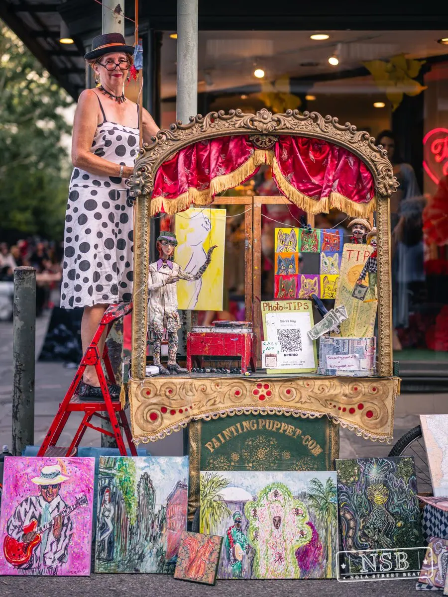 Artist with a colorful sidewalk display during Dirty Linen Night 2026 on Royal Street