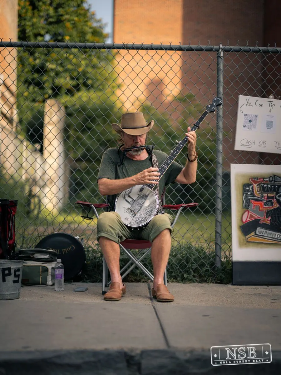 Street musician performing beside Royal Street during Dirty Linen Night 2026