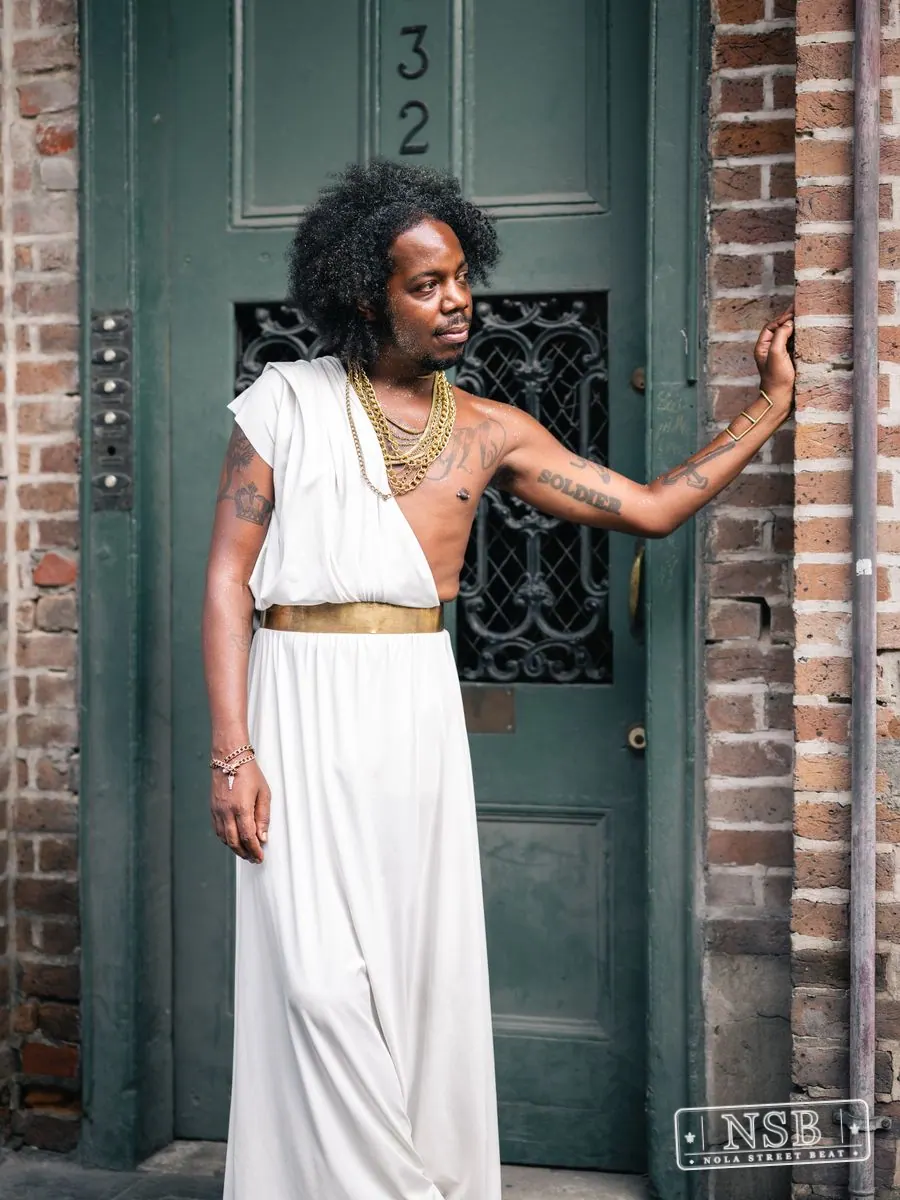 Woman in a white dress posing in a French Quarter doorway at Dirty Linen Night 2026
