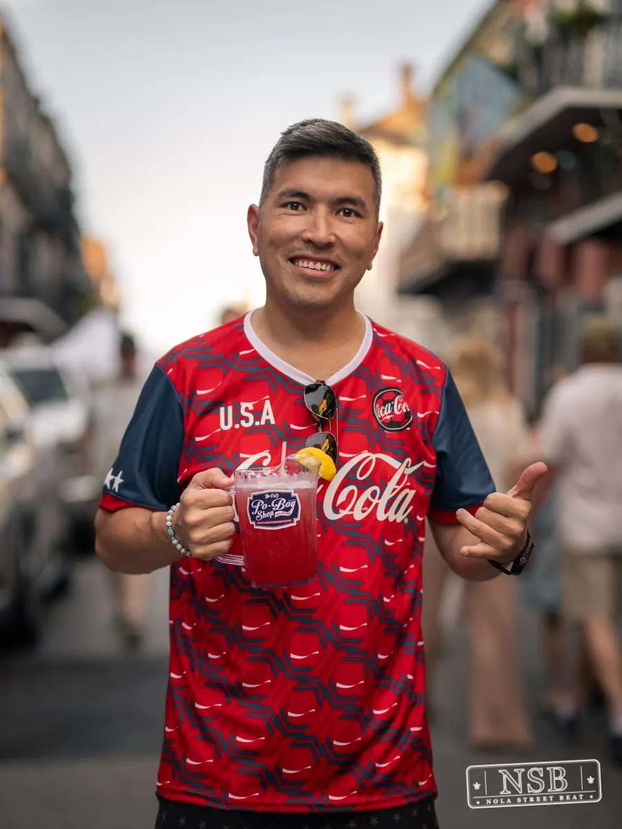 Attendee posing with a drink on Royal Street during Dirty Linen Night 2026