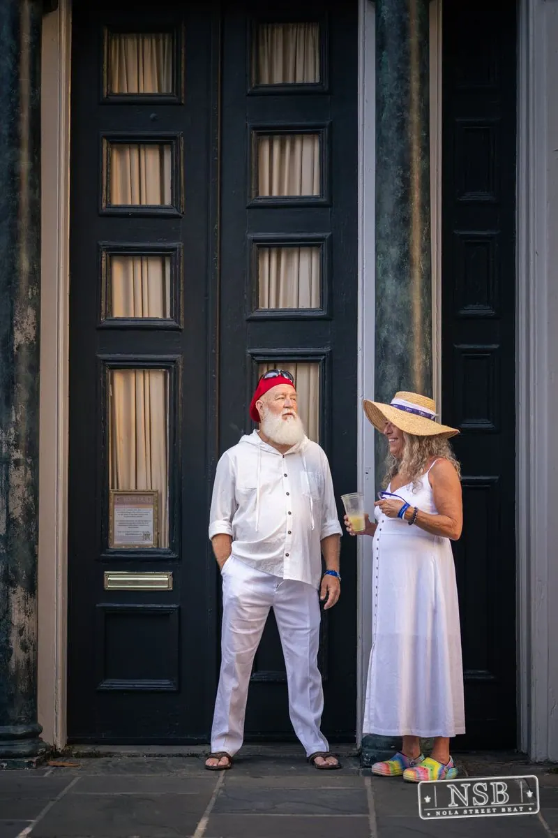 Two attendees framed by an ornate French Quarter doorway at Dirty Linen Night 2026