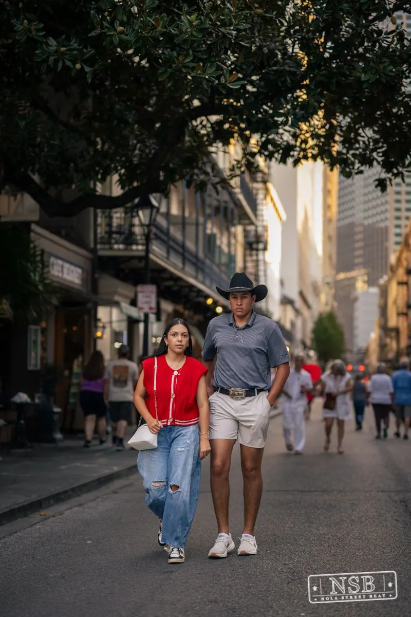 Pedestrians strolling beneath trees during Dirty Linen Night 2026 on Royal Street