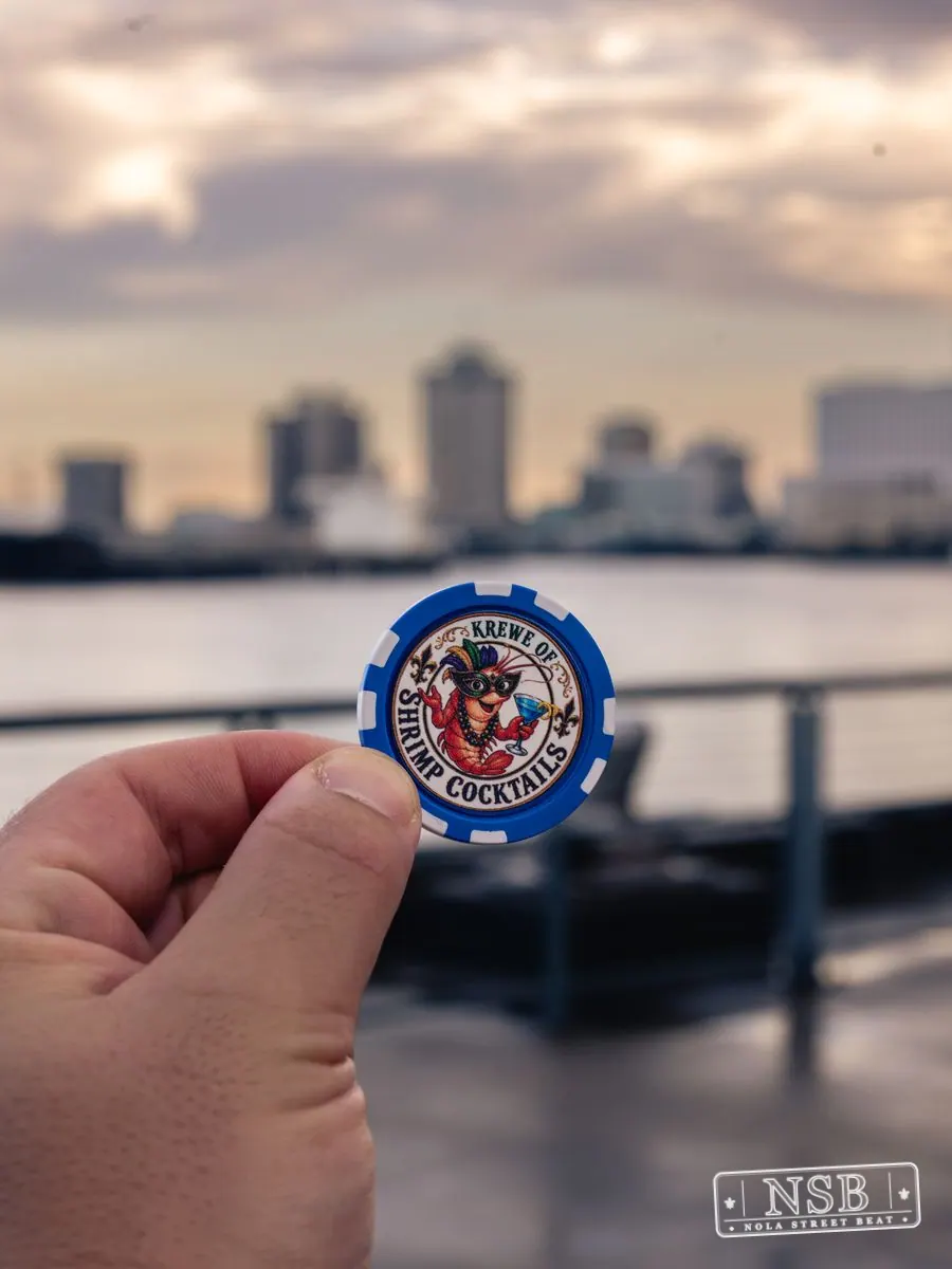 A Mermaid Parade keepsake held against the New Orleans riverfront skyline at the 2026 New Orleans Mermaid Parade