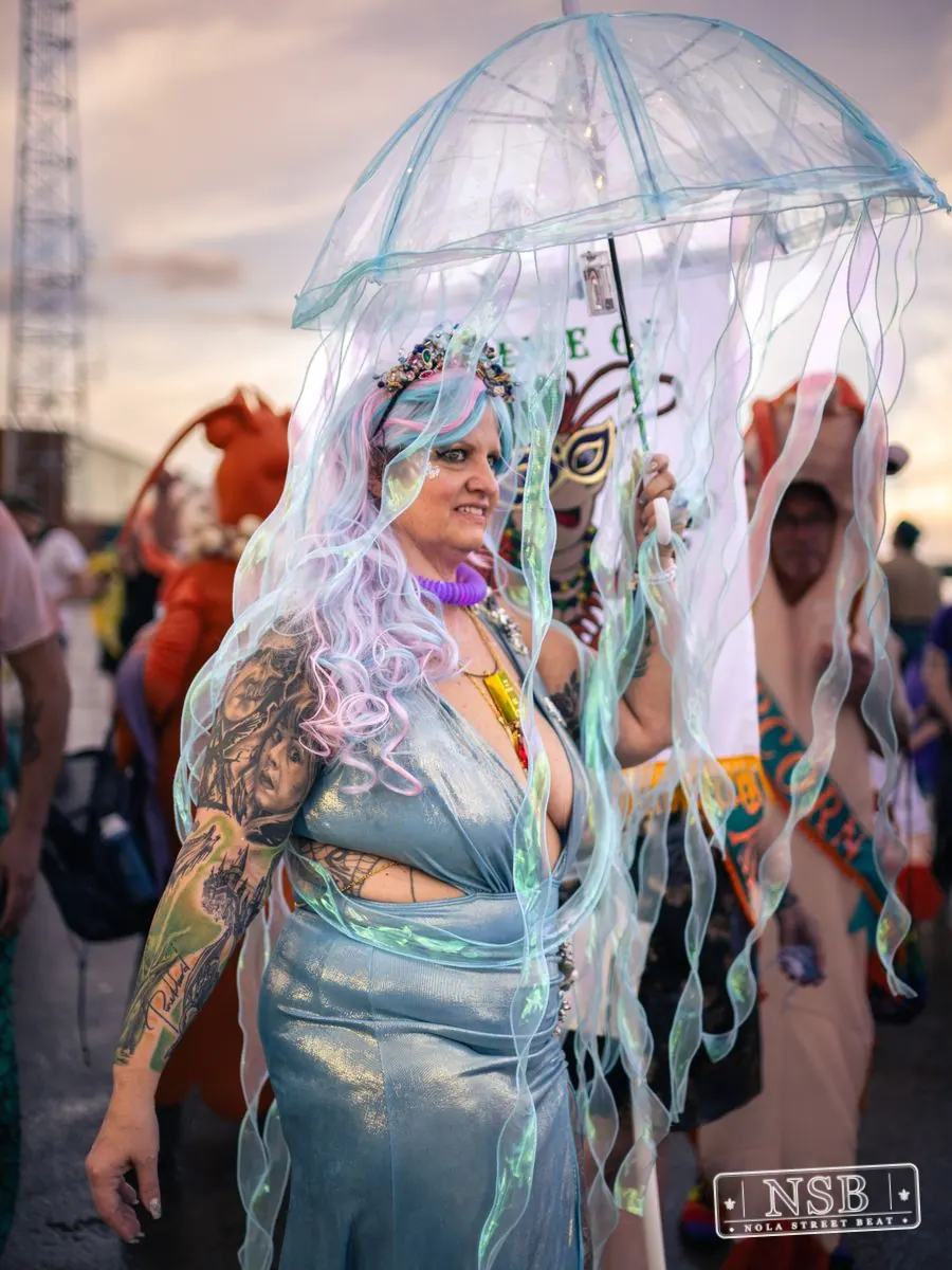 A participant wearing a jellyfish-inspired costume with a translucent umbrella at the 2026 New Orleans Mermaid Parade