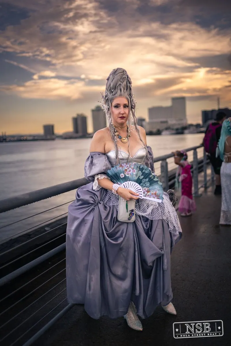 A participant in a lavender sea-inspired gown and elaborate crown at the 2026 New Orleans Mermaid Parade
