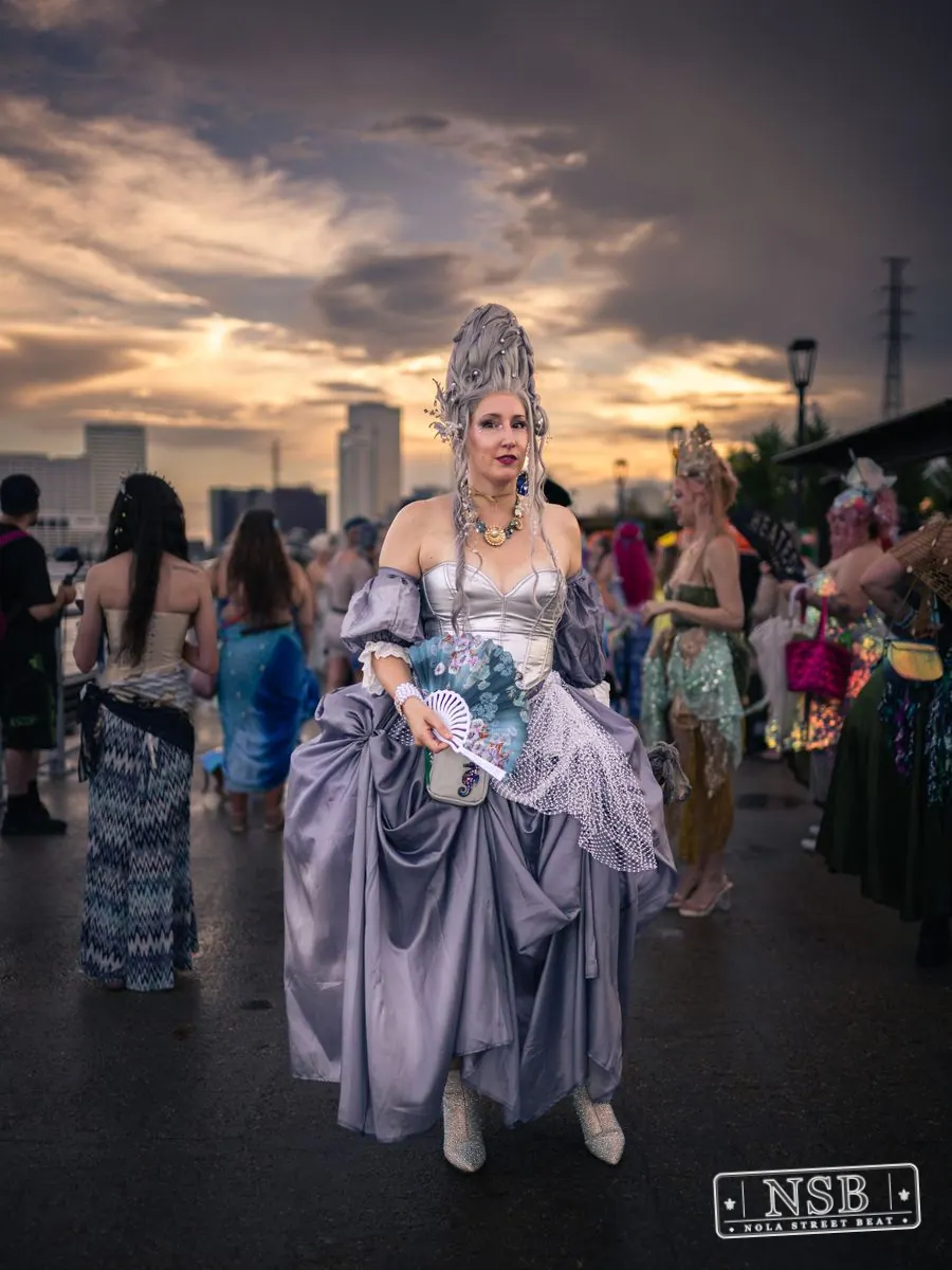 A participant in a lavender sea-inspired gown and elaborate crown at the 2026 New Orleans Mermaid Parade