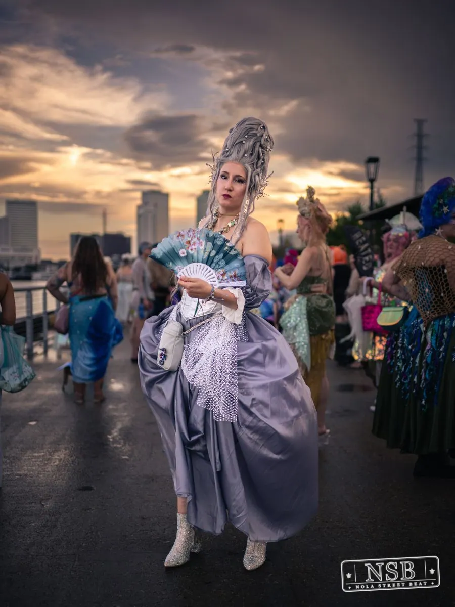 A participant in a lavender sea-inspired gown and elaborate crown at the 2026 New Orleans Mermaid Parade