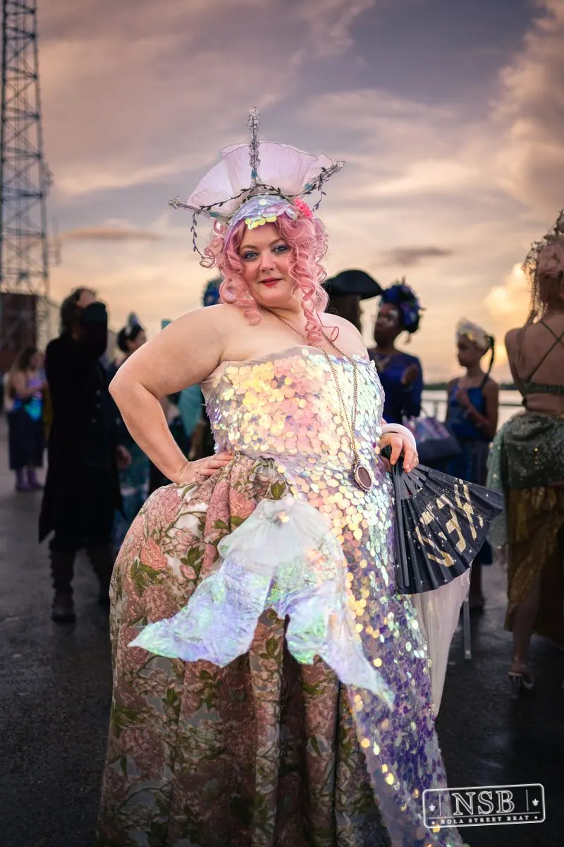 A participant in a pastel mermaid costume and decorative headpiece at the 2026 New Orleans Mermaid Parade