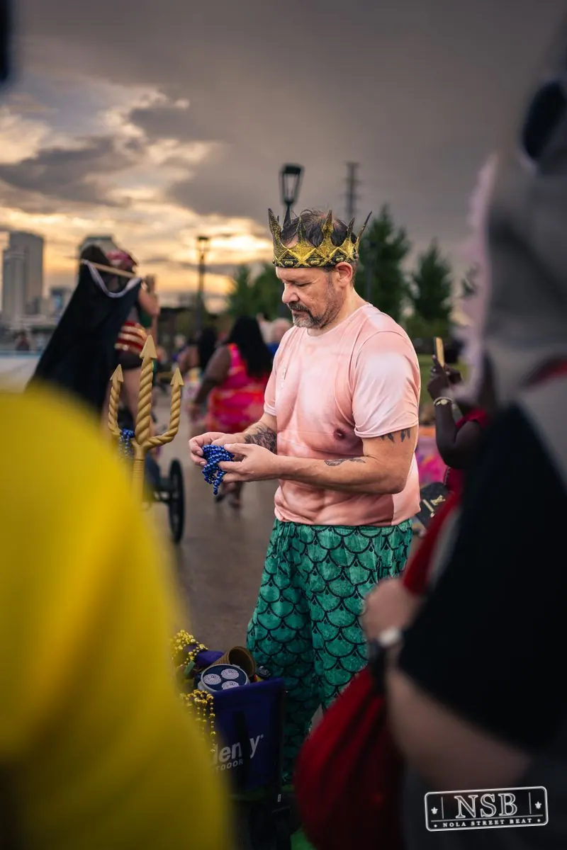 A costumed participant wearing a green mermaid tail at the 2026 New Orleans Mermaid Parade