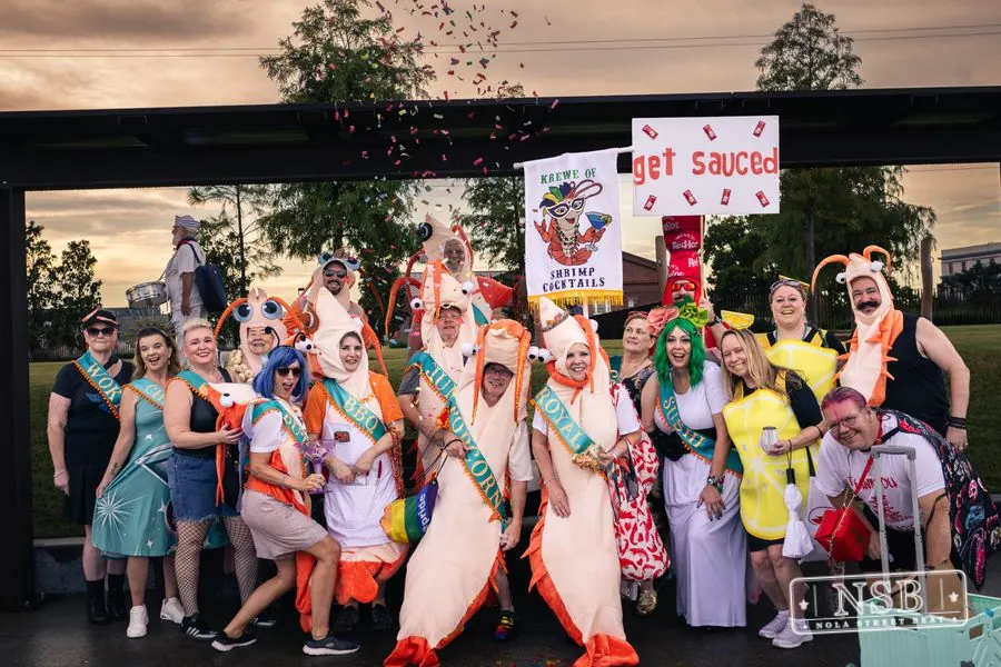 A colorful group of sea-themed parade participants posing beneath a pavilion at the 2026 New Orleans Mermaid Parade
