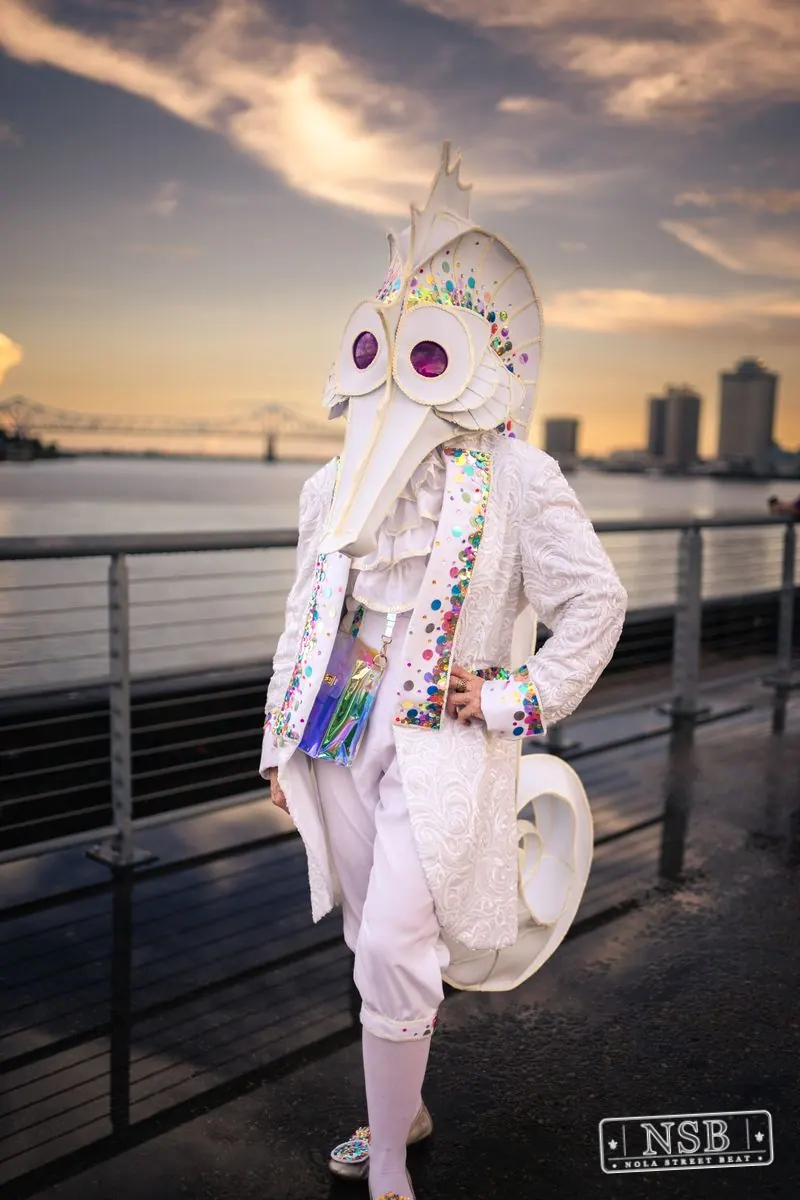 A participant in a white seahorse costume posing along the riverfront at the 2026 New Orleans Mermaid Parade