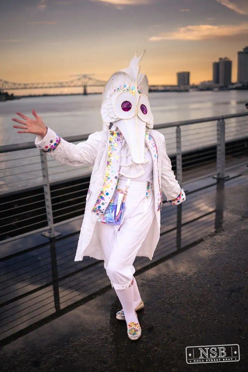 A participant in a white seahorse costume posing along the riverfront at the 2026 New Orleans Mermaid Parade