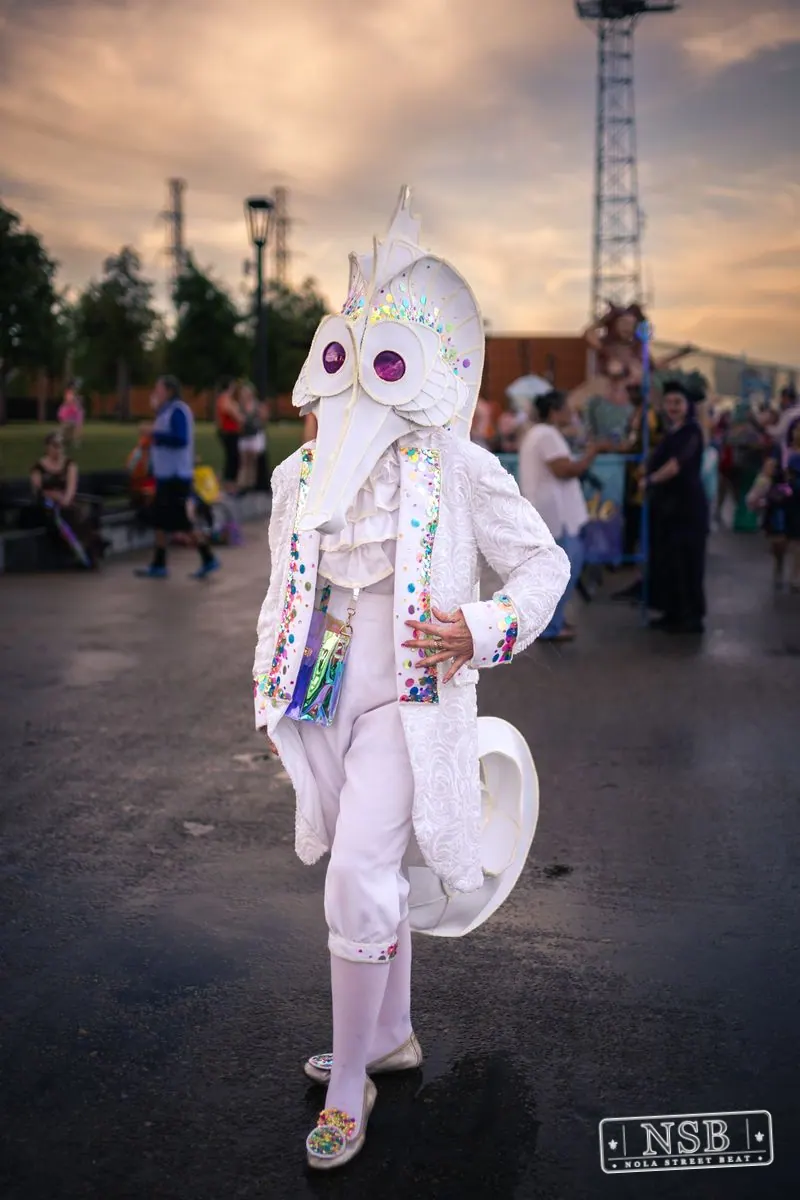 A participant in a white seahorse costume posing along the riverfront at the 2026 New Orleans Mermaid Parade