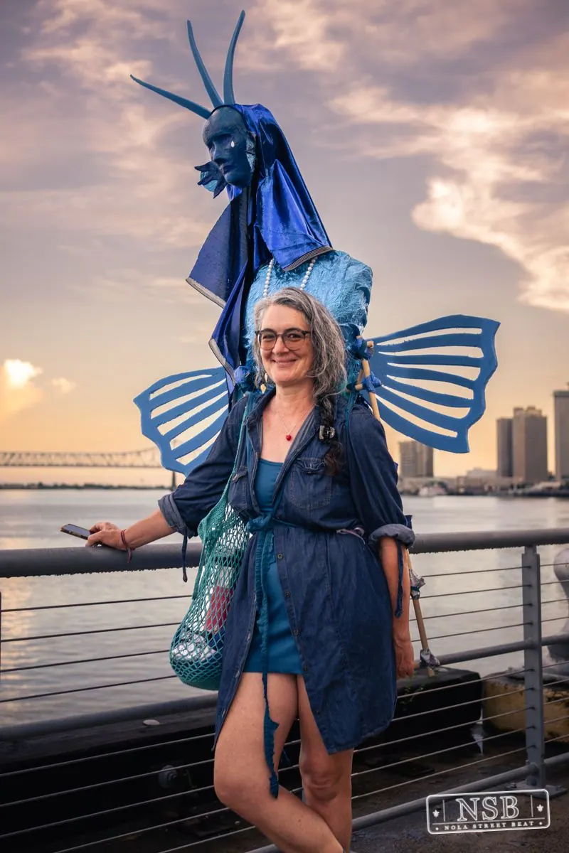 A smiling participant in a blue fin-inspired costume at the 2026 New Orleans Mermaid Parade