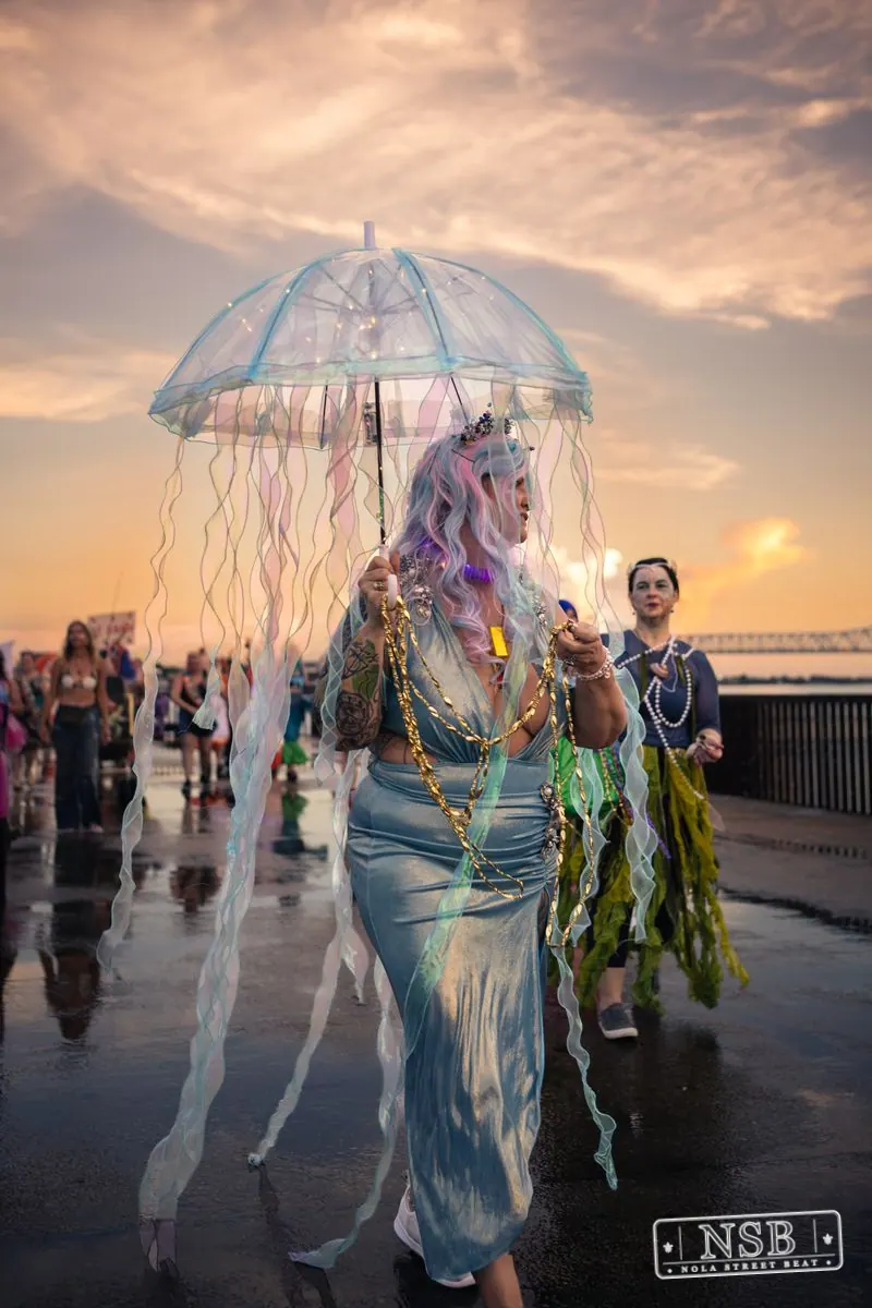 Jellyfish umbrella costumes moving along the riverfront parade route at the 2026 New Orleans Mermaid Parade