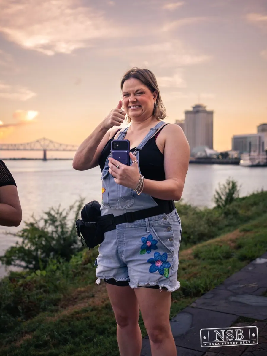 A spectator smiling beside the river during the Mermaid Parade at the 2026 New Orleans Mermaid Parade