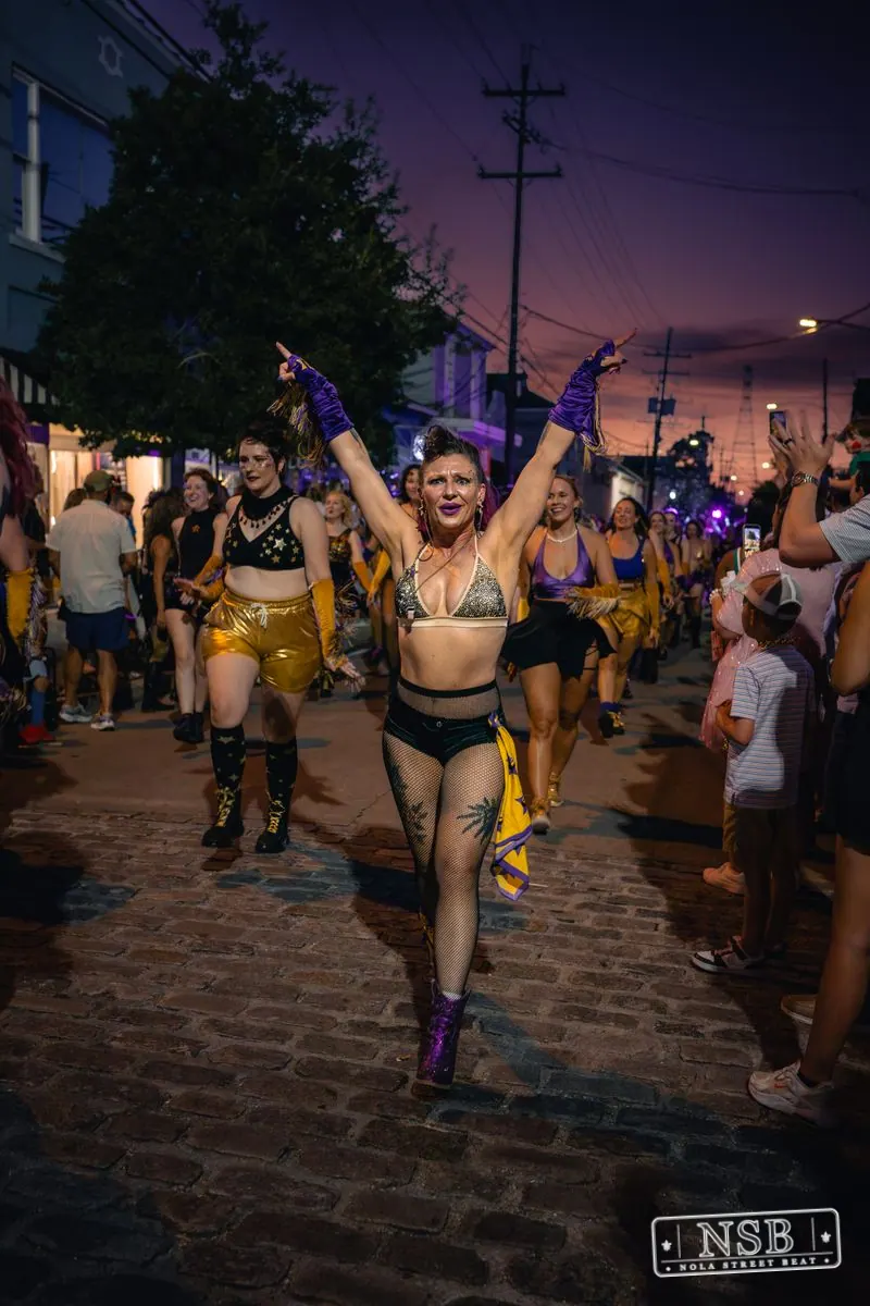 Costumed dancers moving through Oak Street during the Midsummer Mardi Gras 2026 parade in New Orleans