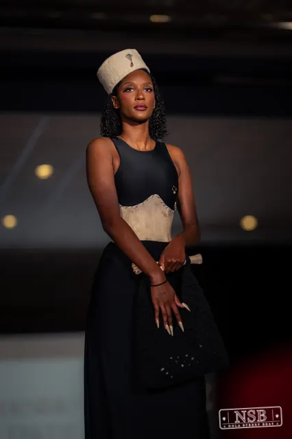 Black gown with beige corset and hat on the runway at New Orleans Fashion Week 2026. Photo 0010 by Nola Street Beat.