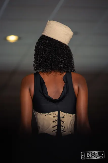 Black gown with beige corset and hat on the runway at New Orleans Fashion Week 2026. Photo 0014 by Nola Street Beat.