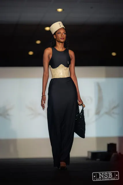 Black gown with beige corset and hat on the runway at New Orleans Fashion Week 2026. Photo 0018 by Nola Street Beat.