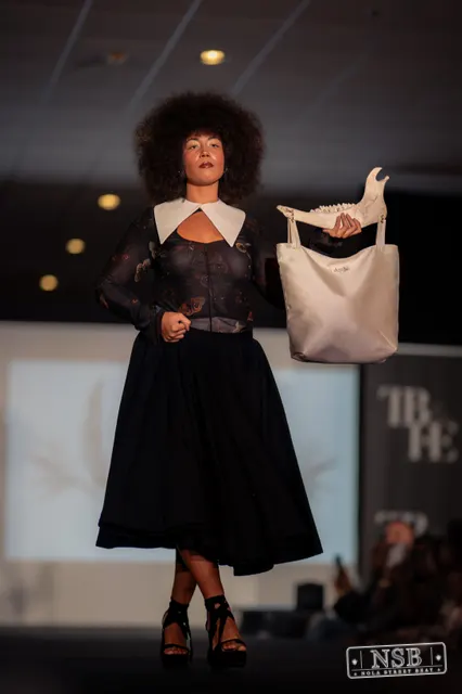 Black lace midi dress with white collar on the runway at New Orleans Fashion Week 2026. Photo 0027 by Nola Street Beat.