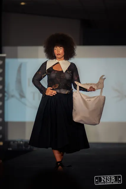 Black lace midi dress with white collar on the runway at New Orleans Fashion Week 2026. Photo 0030 by Nola Street Beat.
