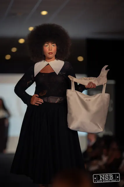 Black lace midi dress with white collar on the runway at New Orleans Fashion Week 2026. Photo 0031 by Nola Street Beat.