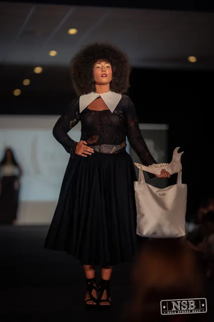 Black lace midi dress with white collar on the runway at New Orleans Fashion Week 2026. Photo 0032 by Nola Street Beat.