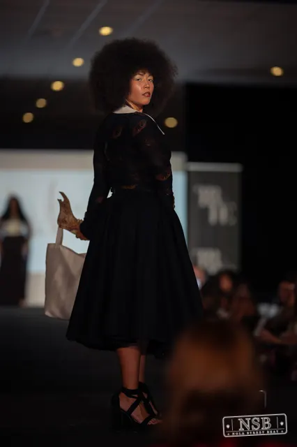 Black lace midi dress with white collar on the runway at New Orleans Fashion Week 2026. Photo 0033 by Nola Street Beat.