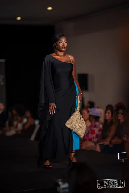 Draped black dress with turquoise panel on the runway at New Orleans Fashion Week 2026. Photo 0036 by Nola Street Beat.