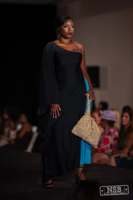 Draped black dress with turquoise panel on the runway at New Orleans Fashion Week 2026. Photo 0037 by Nola Street Beat.