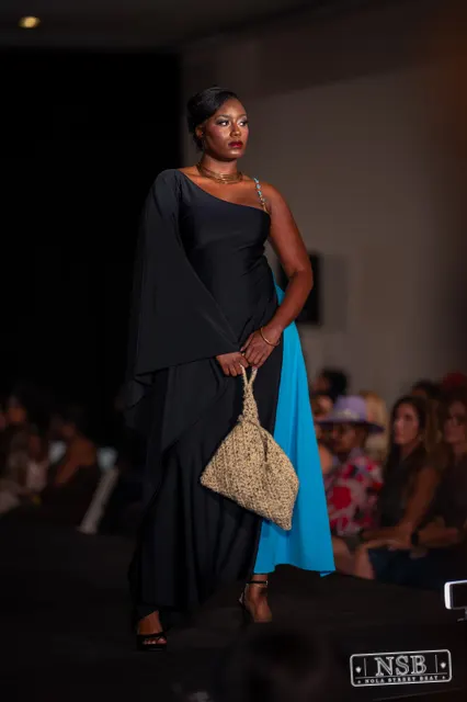 Draped black dress with turquoise panel on the runway at New Orleans Fashion Week 2026. Photo 0038 by Nola Street Beat.