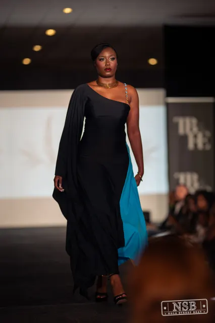 Draped black dress with turquoise panel on the runway at New Orleans Fashion Week 2026. Photo 0043 by Nola Street Beat.