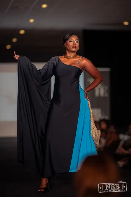 Draped black dress with turquoise panel on the runway at New Orleans Fashion Week 2026. Photo 0047 by Nola Street Beat.