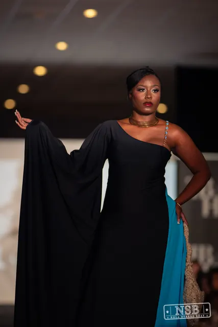 Draped black dress with turquoise panel on the runway at New Orleans Fashion Week 2026. Photo 0048 by Nola Street Beat.