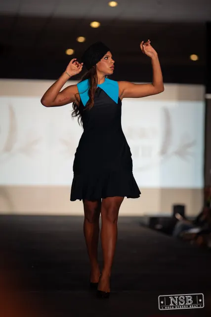 Black mini dress with turquoise collar on the runway at New Orleans Fashion Week 2026. Photo 0051 by Nola Street Beat.