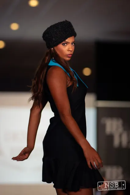 Black mini dress with turquoise collar on the runway at New Orleans Fashion Week 2026. Photo 0060 by Nola Street Beat.